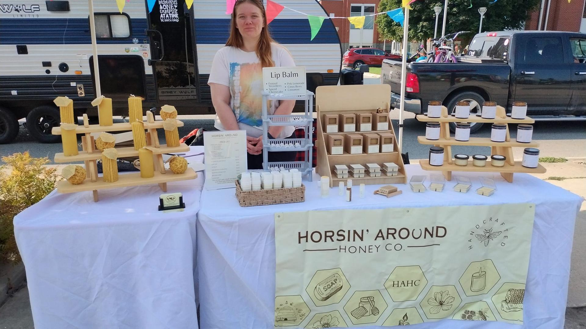 Vendor at Eat Well Farmer's Market in Hanover Horsin' Around beeswax candles and lip balm