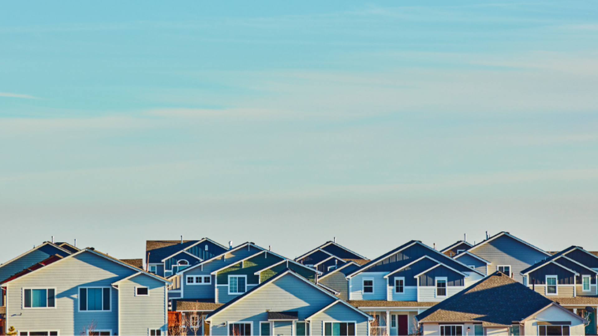 A group of two story houses with blue sky above