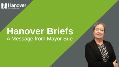 A green and grey background with a photo of Mayor Sue. Text says Hanover Briefs A Message from Mayor Sue